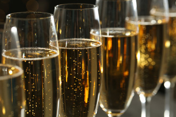 Glasses of champagne on dark background, closeup