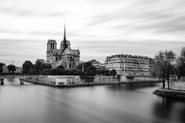 Black and white view of the Cathedral Notre Dame on the ice de la cite, with the river Seine in foreground. Longtime Exposure