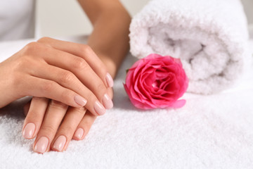 Closeup view of beautiful female hands and rose on towel, space for text. Spa treatment
