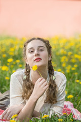 Portrait of a girl among the yellow dandelions.