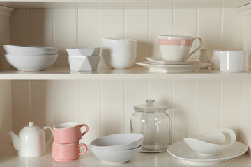 Fototapeta na wymiar Stylish storage stand with different ceramic dishware at home