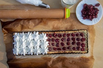 cooked tart with cherries, chocolate creme and meringue