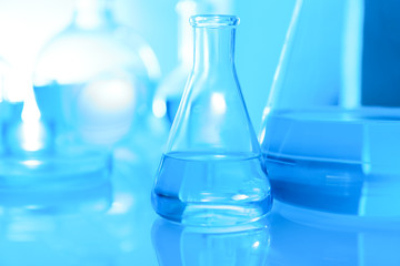 Laboratory glassware with liquid on table. Space for text