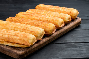 Home made corn dogs, on a dark wooden background. Classic american food