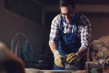 Carpenter sanding with electric sander polisher 