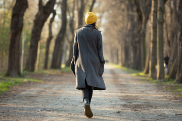 Rear view of a young woman walking on an avenue .