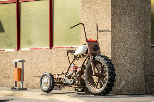 An old motorcycle stands against the wall.