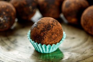 Vegan chocolate truffles on a brass plate. Vegan chocolate truffles. close up. Space