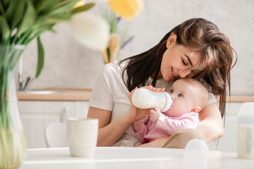 Obraz na płótnie Canvas Feeding newborn girl with formula in a bottle.
