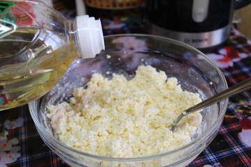  photo home cooking.in a bowl of cottage cheese mixture.it is added vegetable oil from the bottle.it is used for pies.its color is white.cookware is transparent.