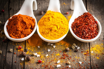 Spices in Wooden spoon. Herbs. Curry, Saffron, turmeric, rosemary, cinnamon, garlic, pepper, anise on wooden rustic background. Collection of spices and herbs. Salt, paprika. Copy space. Top view. Ban