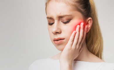 Young womanhaving strong toothache and suffering from pain