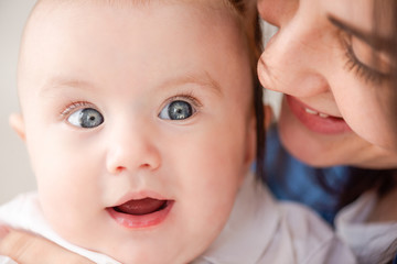Portrait of lovely infant blue eyes in mom hugs