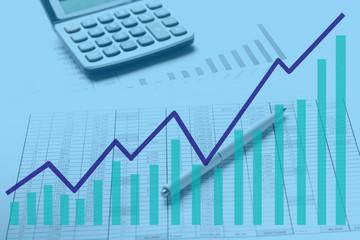 Accountant work table with calculator, charts and pen.