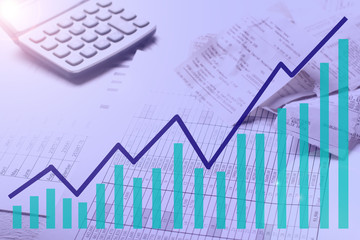 Accountant work table with calculator, charts and pen.