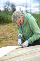 An adult man sawing boards electric jigsaw for building a house