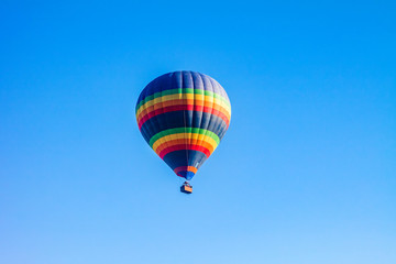Colorful hot air balloons over blue sky.
