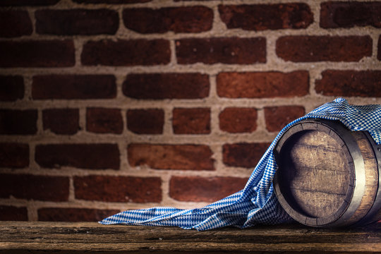 Oktoberfest wooden barrel and blue tablecloth on rustic oak table