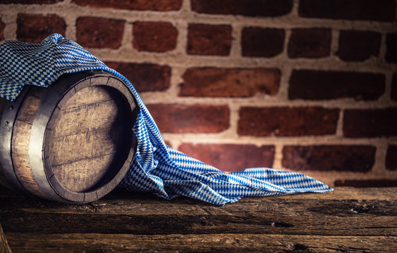 Oktoberfest wooden barrel and blue tablecloth on rustic oak table