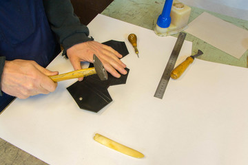 Fototapeta na wymiar Craftsman workin on coffin leather wallet