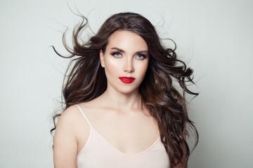 Naklejka premium Brunette model woman with long perfect hair and red lips makeup on white background