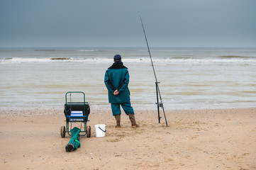 Old fisherman looking at the sea on a beach