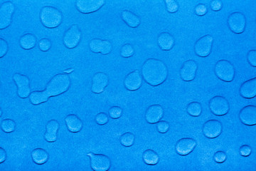 Drops of water on a blue smooth surface. Top view