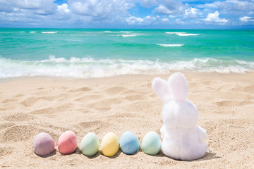 Beach Easter background with bunny and color eggs