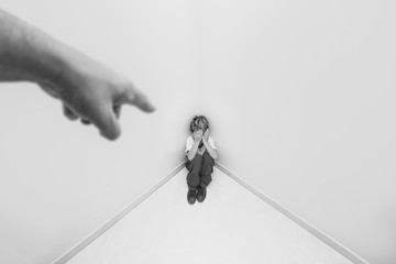 Adult hand pointing at child in school uniform crying, concept of child abuse or bullying.