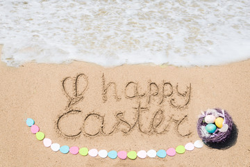 Happy easter lettering background with eggs on the sandy beach
