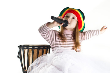 Joyful rastafarian toddler girl sinnging in a microphone