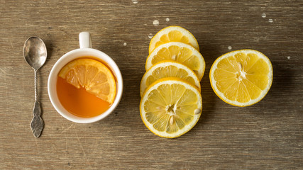 Fototapeta na wymiar Herbata z cytryną w otoczeniu cytryny i kanapek