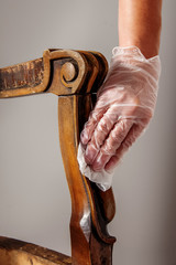 Renovation of old furniture as an antique Victorian old wooden armchair. Polishing and cleaning the...