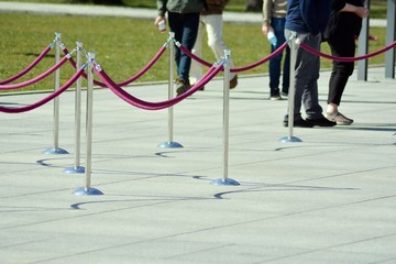 Silver stanchions with a purple rope.