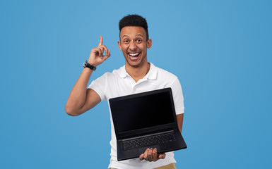 Excited black man presenting good deal on laptop