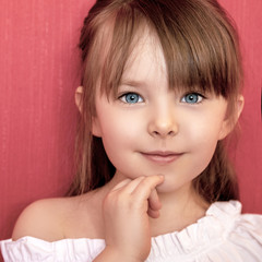 Cute little girl smiling over bright pink background