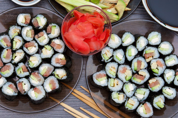 Sushi rolls set served on black stone plate on dark background. Flat lay, top view. Homemade japanese menu.