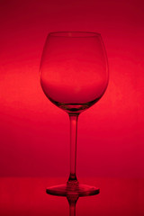 Empty wine glass on red background, empty wineglass