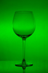 Empty wine glass on green background, empty wineglass