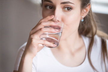 Close up top view woman drinking clear water from glass