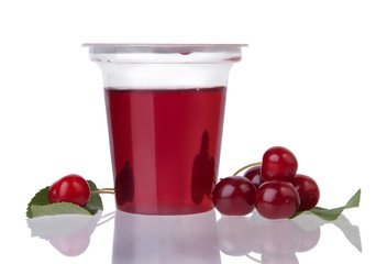Red jelly in plastic transparent cup and cherry berries isolated on white background