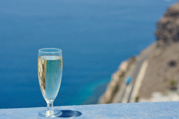 The glass of white crystal and sparkling wine against the wonderful ocean view.