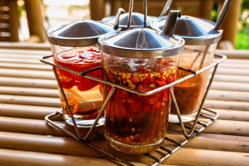 Traditional chili in a glass jar with herbs in olive oil.