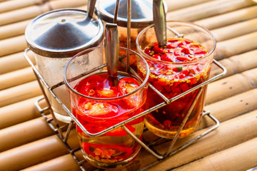 Traditional chili in a glass jar with herbs in olive oil.