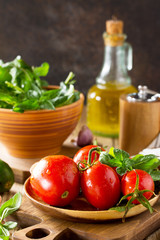 Healthy food: fresh vegetables on the kitchen wooden table. Fresh tomatoes, cucumbers and rucola for cooking salad. Diet menu. Copy space.
