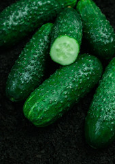 vegetable cucumbers ground black background ripe mature green greens several