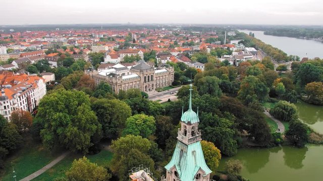 Hannover, Germany a bird's-eye view. The green dome of the municipality compared to other authentic houses. Many green spaces and trees. In the frame of the road, cars. Slow Motion.