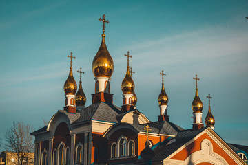 Fototapeta premium The setting sun is beautifully reflected in the gilding of church crosses