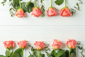 Flat lay composition with pink roses and space for text on white background