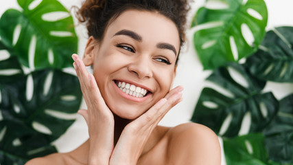 African-american girl with perfect skin over tropical leaves